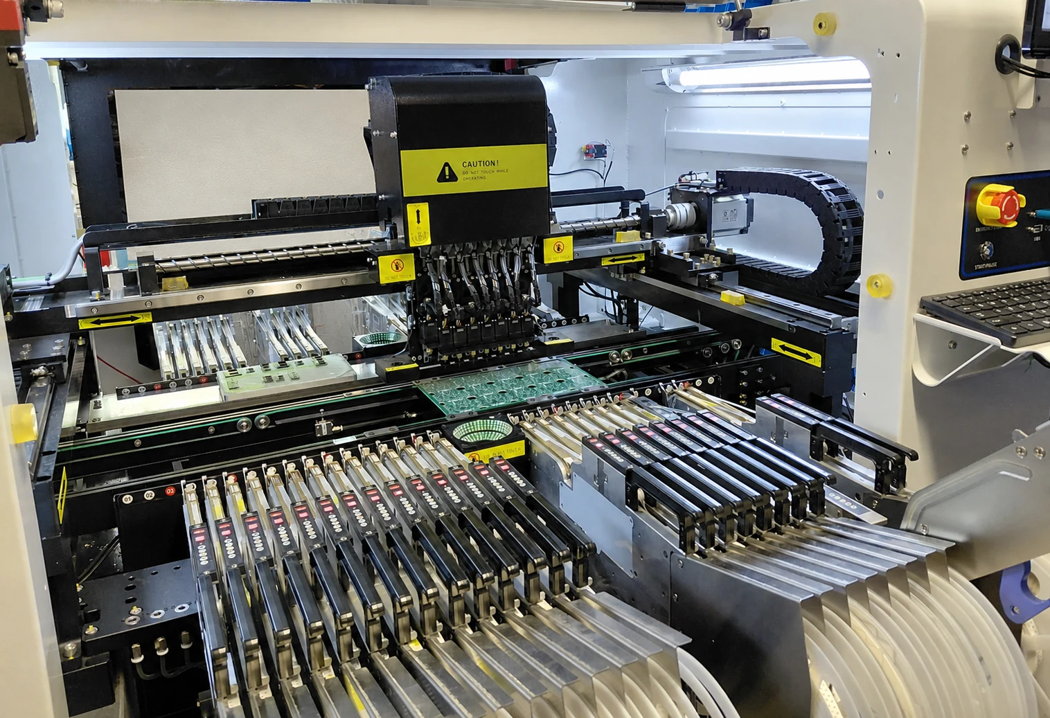 Surface-mount placement machine assembling a populated circuit board.